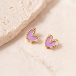 Heart-shaped earrings with pink hearts and gold frames on a beige background